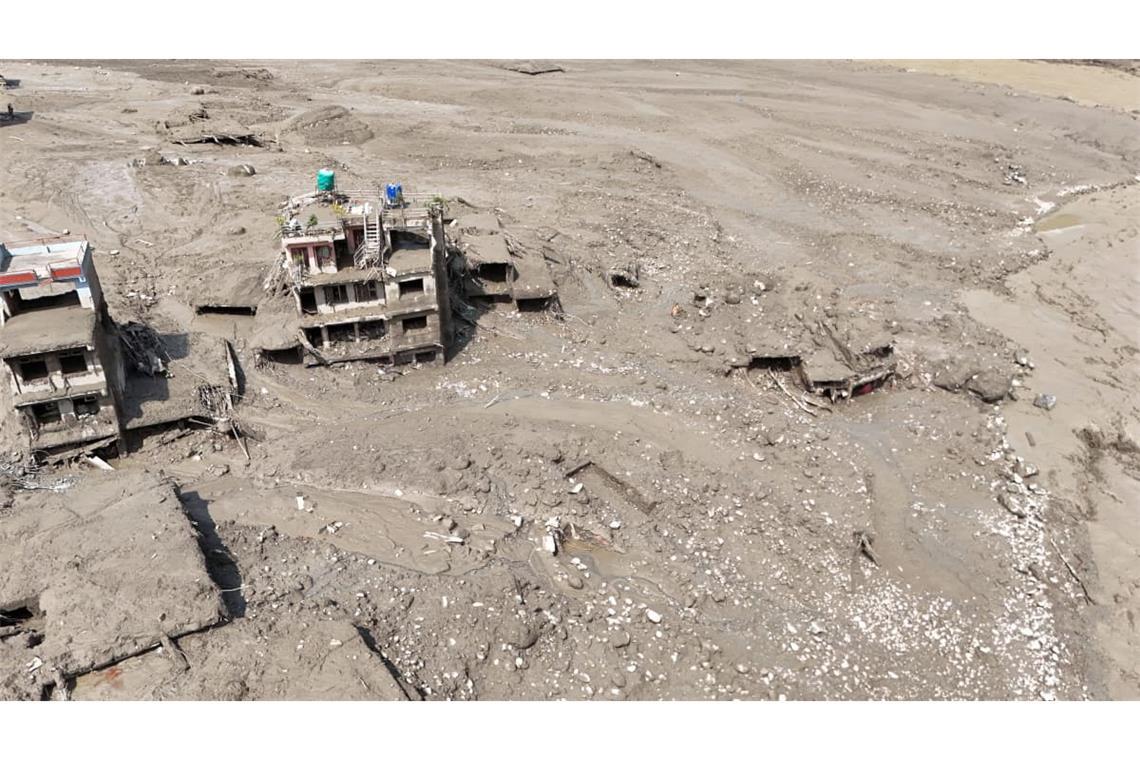 Beschädigte Gebäude und Infrastruktur entlang des angeschwollenen Trishuli-Flusses. 