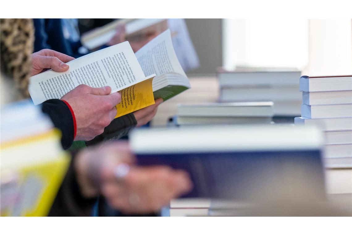 Jeder Sechste in Deutschland liest keine Bücher mehr Besucher der Leipziger Buchmesse lesen im März 2024 am Stand eines Verlages.