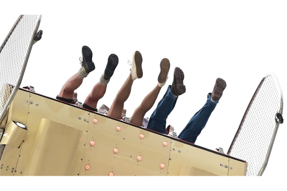Besucher des Volksfests Cannstatter Wasen in Stuttgart sitzen in einem Fahrgeschäft. Der "Wasen" ist nach dem Münchner Oktoberfest das zweitgrößte Volksfest in Deutschland.