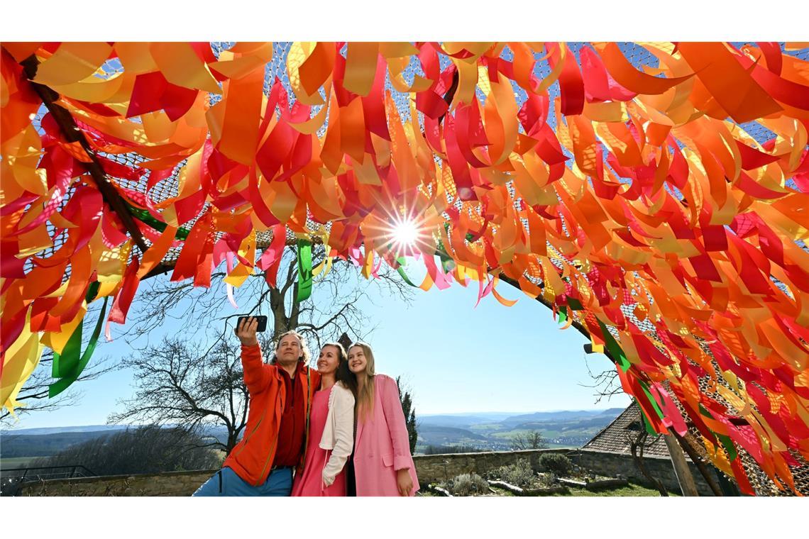 Bilder des Tages Besucher fotografieren sich vor bunten Bändern, die Teil der Dekoration des Frühlingszaubers auf der Leuchtenburg sind