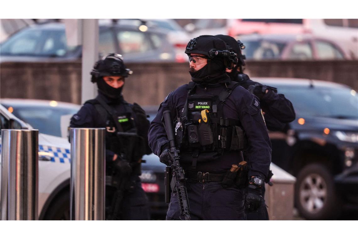 Bewaffnete Polizisten arbeiten am Tatort nach einem Schusswaffenangriff am Bondi Beach.