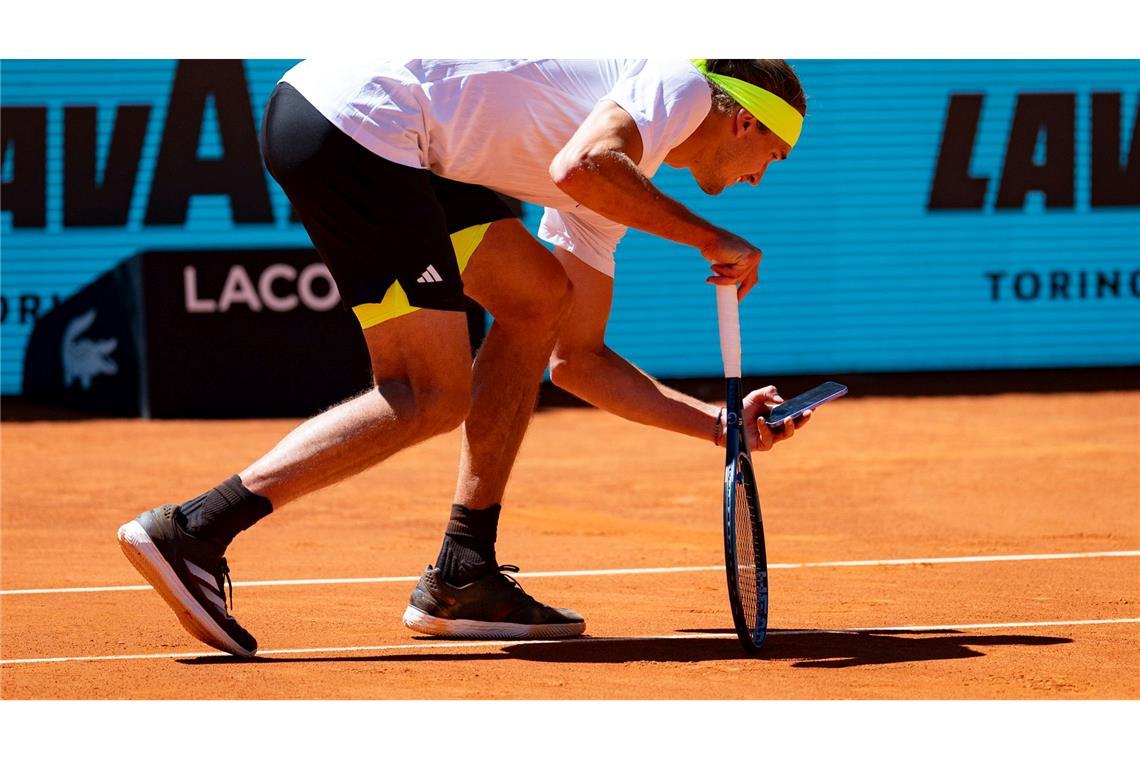Bilder des Tages Beweismittelaufnahme: Alexander Zverev fotografiert mit seinem Handy den Abdruck des Balls auf der Linie.