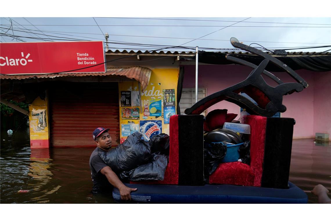 Bewohner bergen Hab und Gut aus überfluteten Häusern in der kolumbianischen Stadt Monteria, nachdem der Fluss Sinu durch Regen über die Ufer getreten ist.