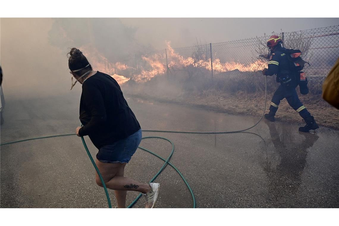 Bewohner und Feuerwehrleute bekämpfen die Flammen.