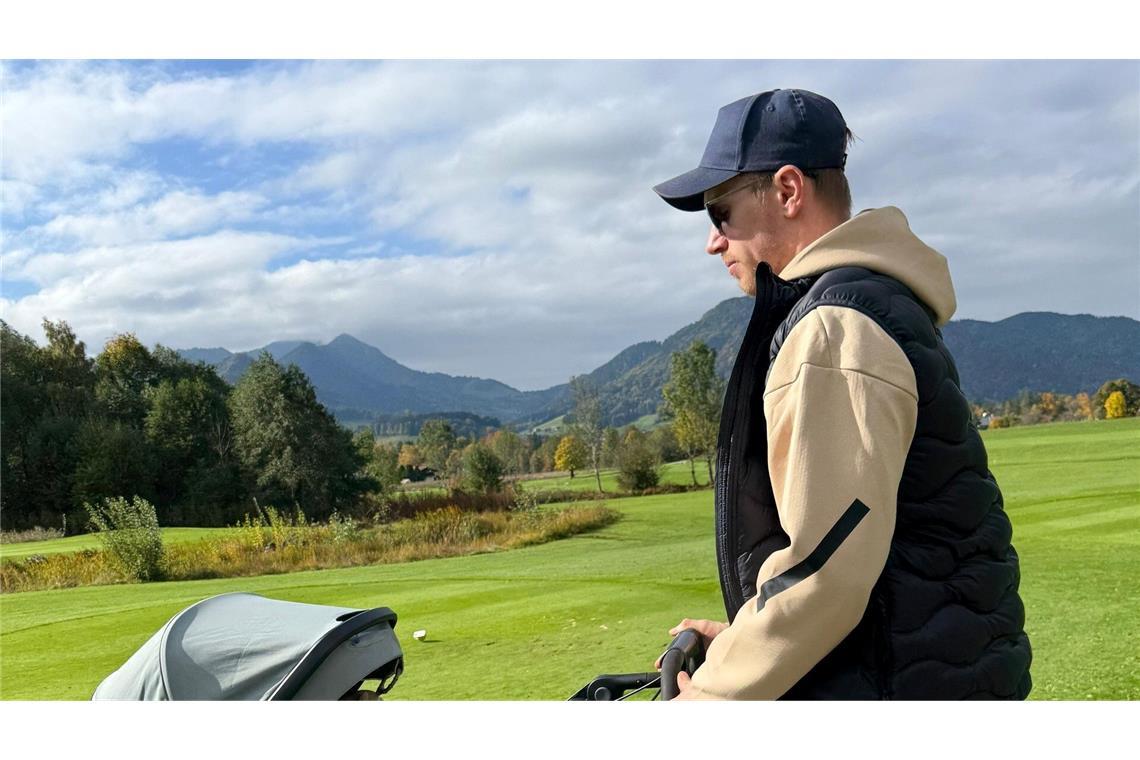 Biathlet Johannes Kühn schiebt seine Tochter im Kinderwagen.