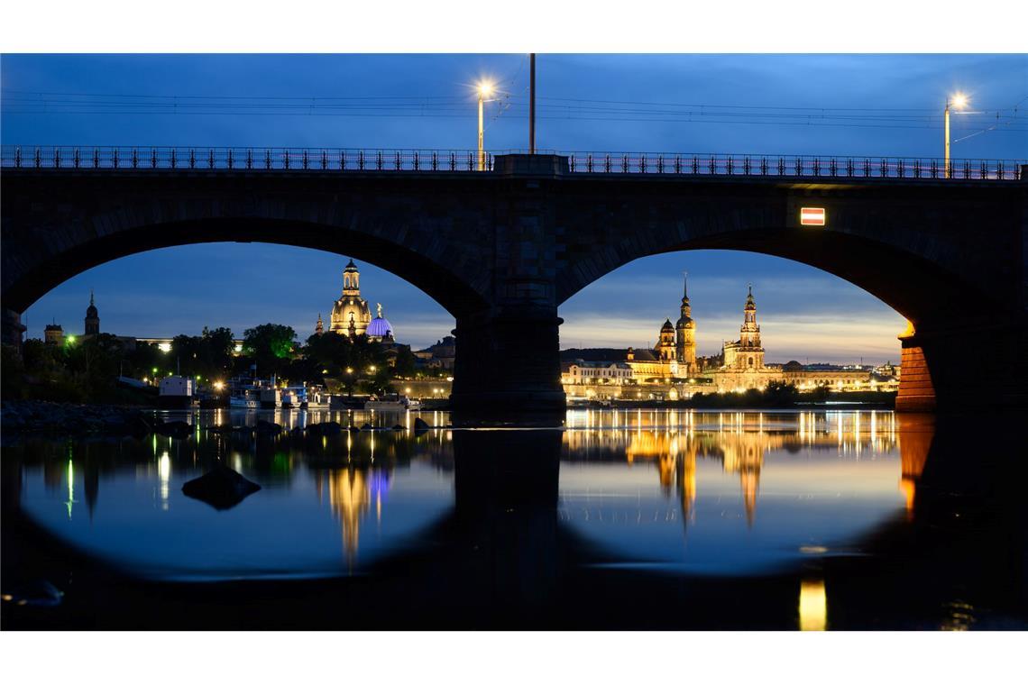 Bilder des Tages Blick am Abend in Dresden durch die Brückenbögen der Albertbrücke auf die historische Altstadtkulisse an der Elbe mit der Frauenkirche (l-r), der Kuppel der Kunstakedmie mit dem Engel „Fama“, dem Terrassenufer, dem Ständehaus, dem Hausmannsturm, der Hofkirche und der Semperoper.