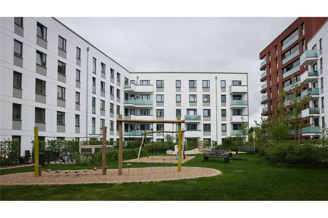 Was bringt die Mietpreisbremse? Blick in den Innenhof einer neuen Wohnanlage mit Grünfläche und Kinderspielplatz am Stadtpark.