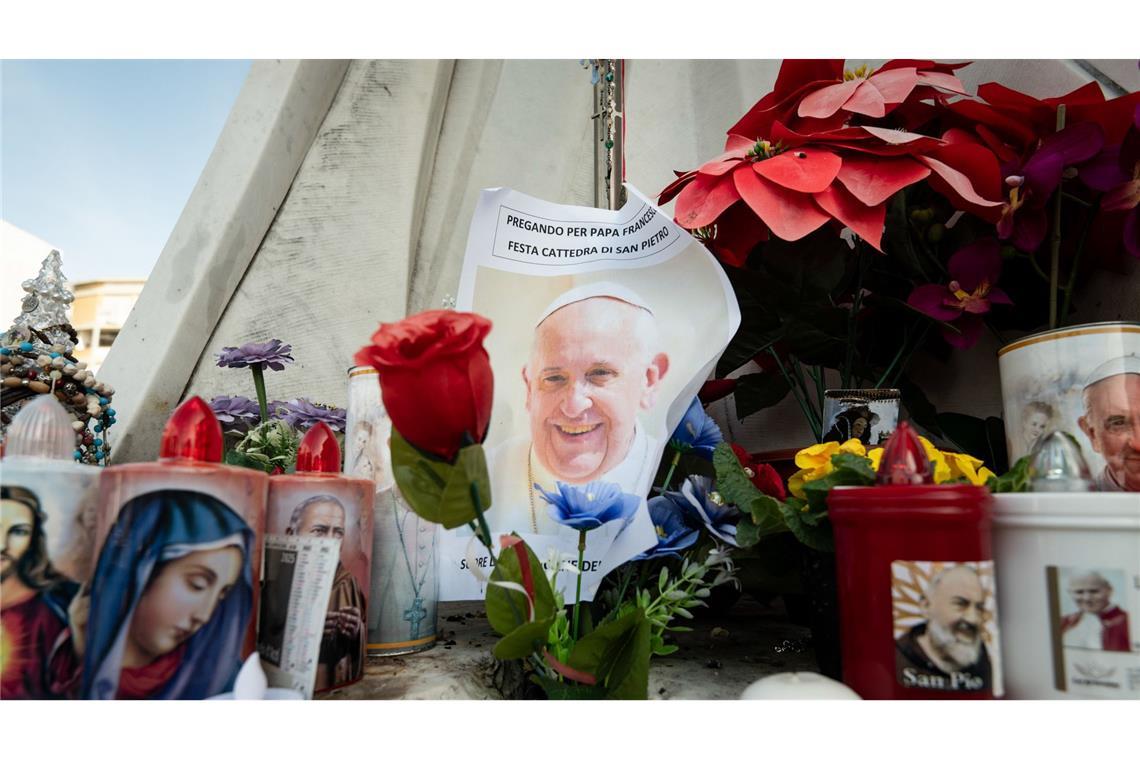 Franziskus bekommt praktisch dauernd Atemhilfe Blumen und Votivkerzen, einige mit dem Abbild von Papst Franziskus, liegen vor dem Gemelli-Krankenhaus in Rom.