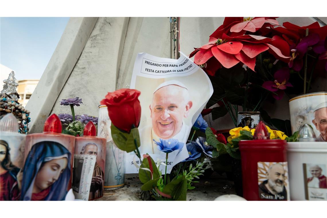 Ruhige Nacht für den kranken Papst - Medizinisches Update am Abend Blumen und Votivkerzen, einige mit dem Abbild von Papst Franziskus, liegen vor dem Gemelli-Krankenhaus in Rom.