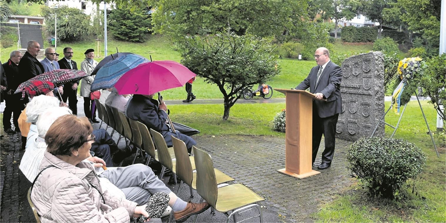 Bürgermeister Armin Mößner (rechts) geht in seiner Rede beim Ehrenmal am Feuersee auf die Geschichte und Hintergründe zum Gedenktag ein. Auf dem Gedenkstein sind die Regionen verzeichnet, aus der Menschen nach dem Zweiten Weltkrieg nach Murrhardt kamen – Pommern, Danzig, Ost- und Westpreußen, Sudetenland, Schlesien und Oberschlesien, Donauschwaben, Siebenbürgen sowie Bessarabien. Foto: J. Fiedler