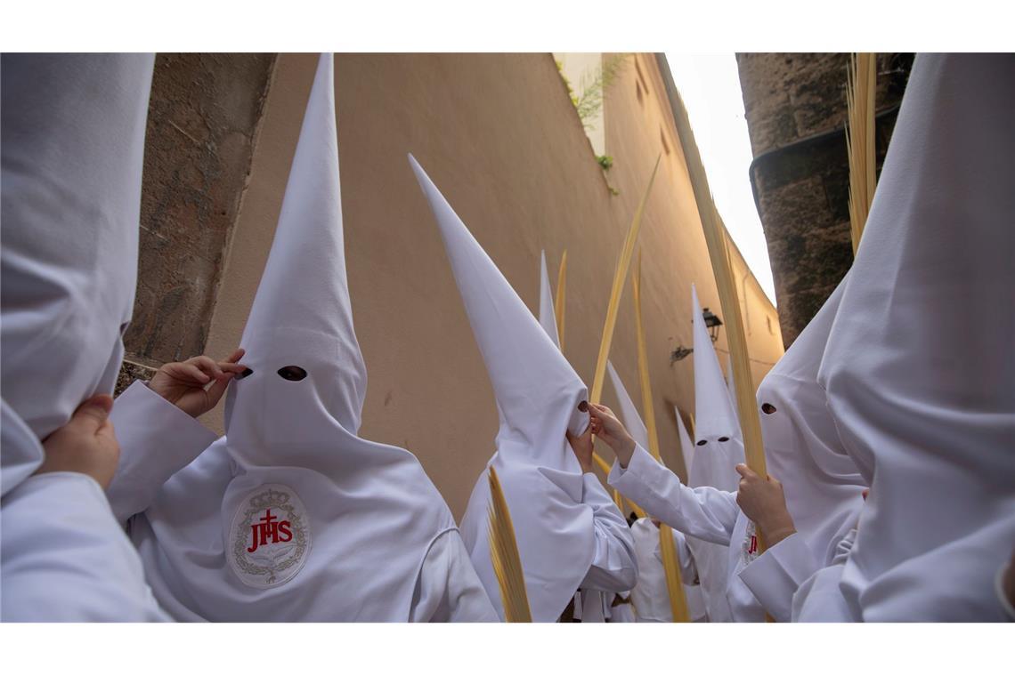 Büßer (Nazarenos) nehmen an einer Prozession am Palmsonntag (Domingo de Ramos) zum Auftakt der Karwoche in Spanien teil.