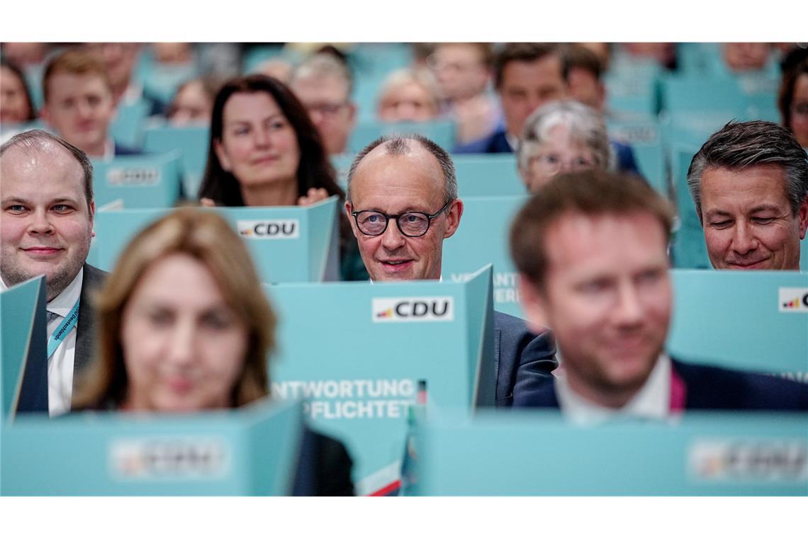 Bundeskanzler Friedrich Merz (M), CDU-Parteivorsitzender, sitzt hinter seiner Wahlkabine.