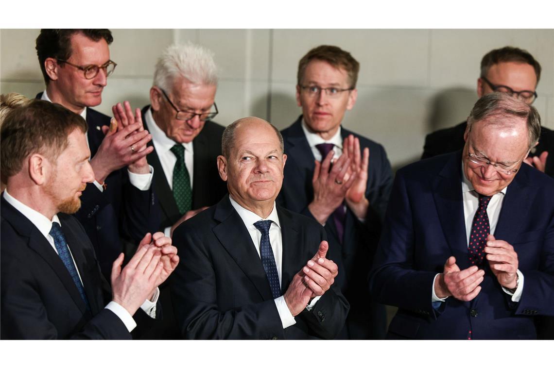 Bilder des Tages Bundeskanzler Olaf Scholz (M, SPD) applaudiert zwischen den Ministerpräsidenten.