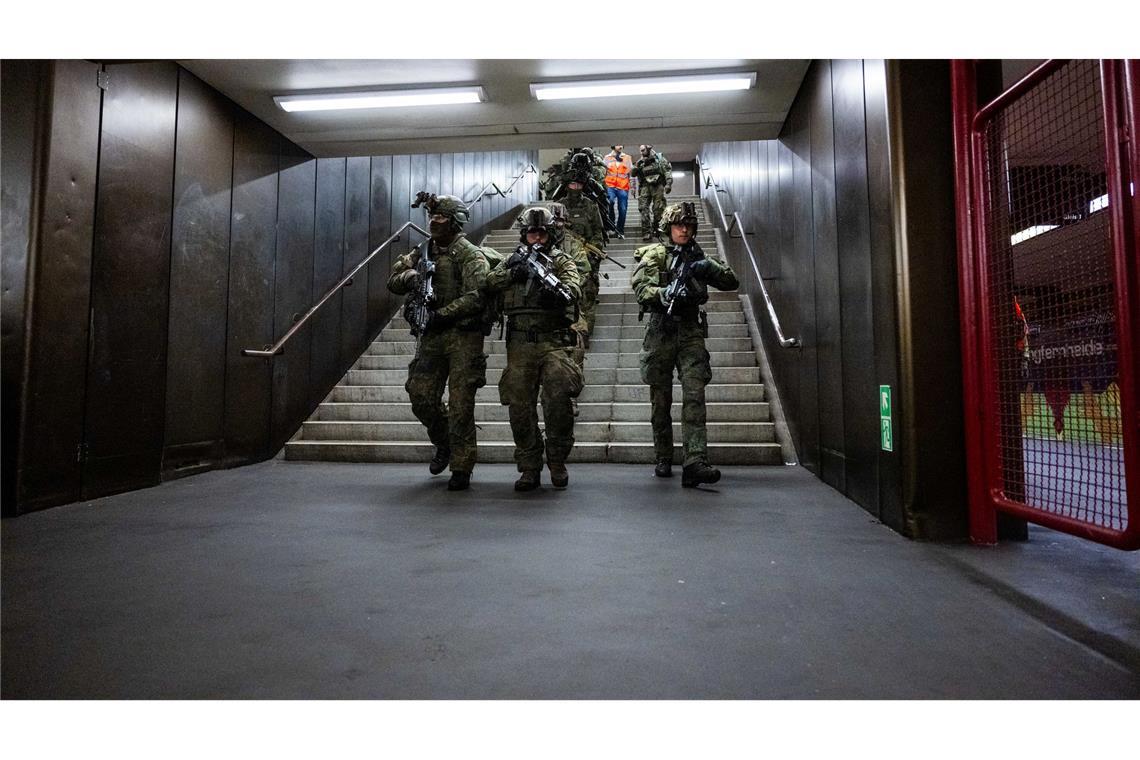 Bundeswehrsoldaten laufen eine Treppe im U-Bahnhof Jungfernheide herunter.