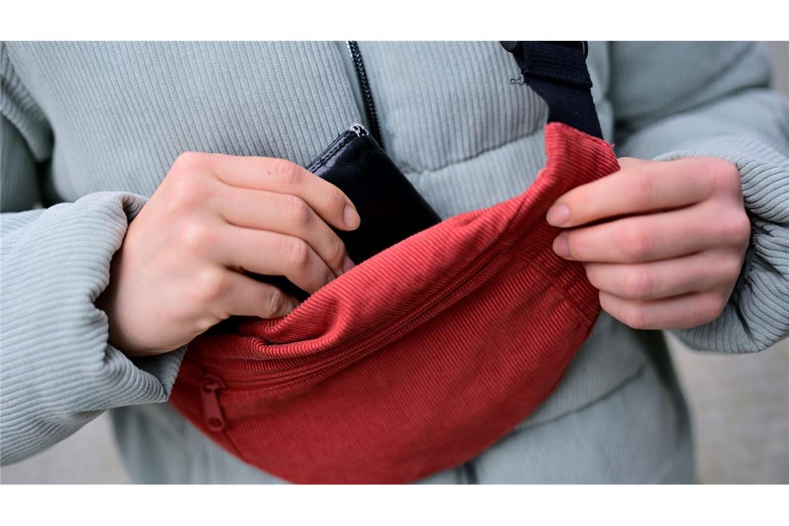 Ripp-Chic für "Drinnies"? Warum es ein Cord-Comeback gibt Cord lässt sich im Alltag wieder öfter antreffen; Eine Frau trägt eine Jacke und eine Brusttasche aus Cord und steckt ihr Portemonnaie in die Tasche. (Foto: Illustration)