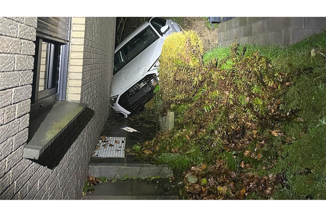 Auto klemmt zwischen Haus und Abhang Das Auto steckt zwischen einem Abhang und dem verklinkerten Wohnhaus fest.