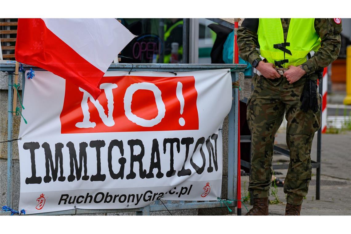 Polen und Deutsche kontrollieren Reisende an der Grenze Das Banner stammt von der rechtsradikalen "Bewegung zur Verteidigung der Grenzen", die zu eigenmächtigen Grenzpatrouillen aufruft.