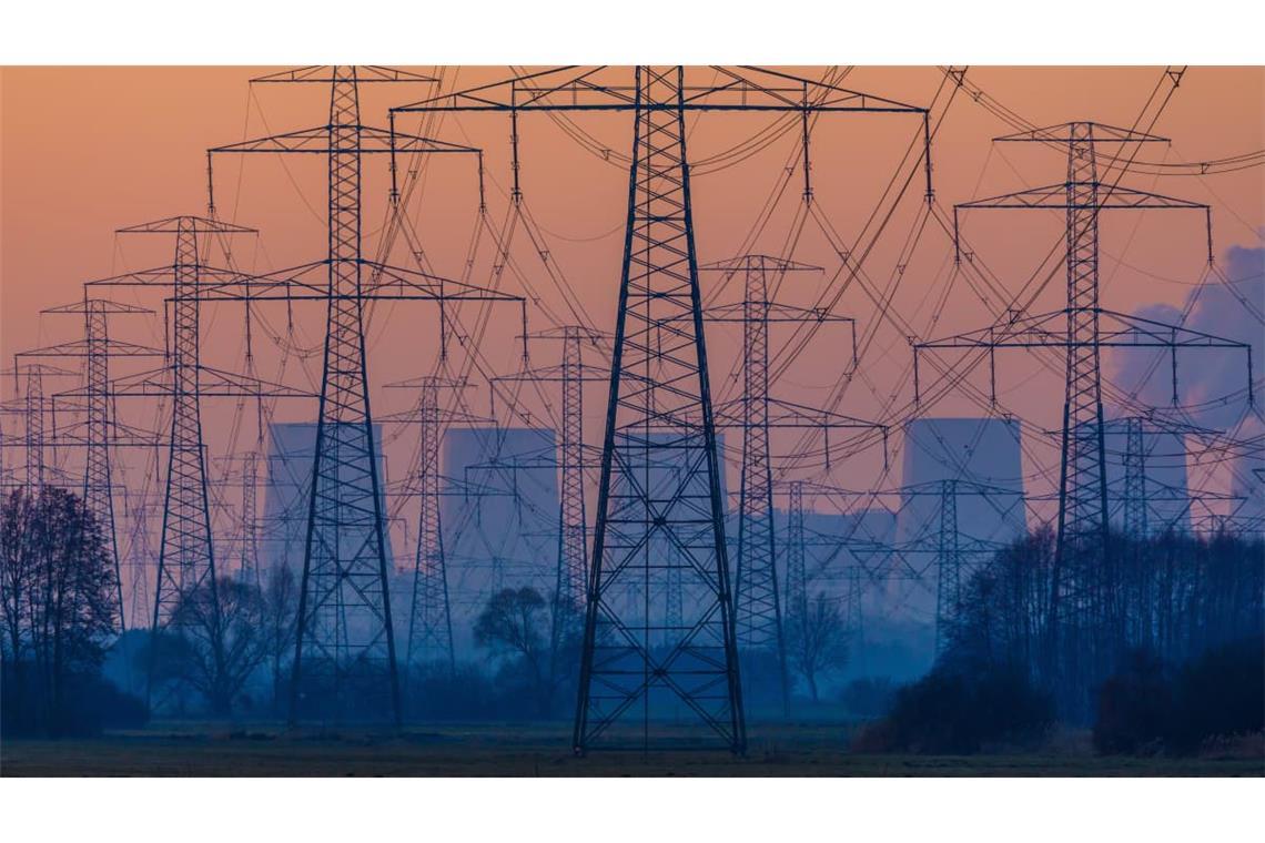 Das Braunkohlekraftwerk Jänschwalde e und Stromleitungsmasten sind bei Sonnenaufgang bei Tauer in der Nähe von Peitz in der Lausitz zu sehen. 