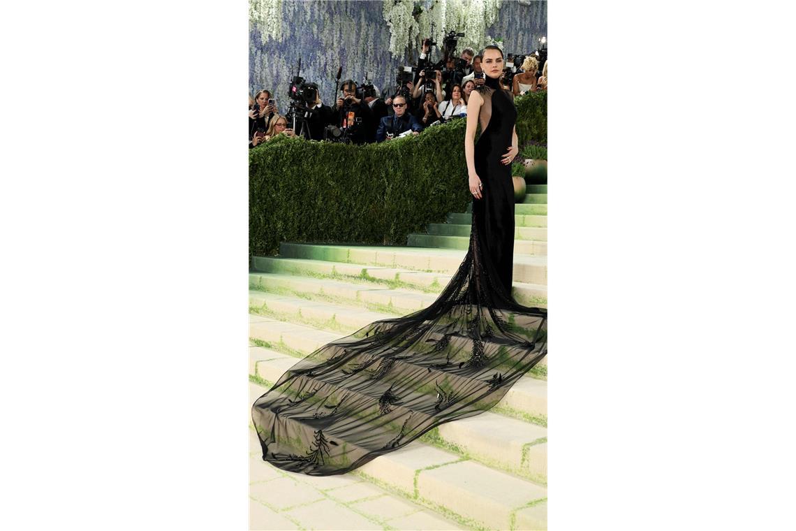 Das Model Cara Delevingne in einem schwarzen Kleid mit XXL-Tüllschleppe von Ralph Lauren.