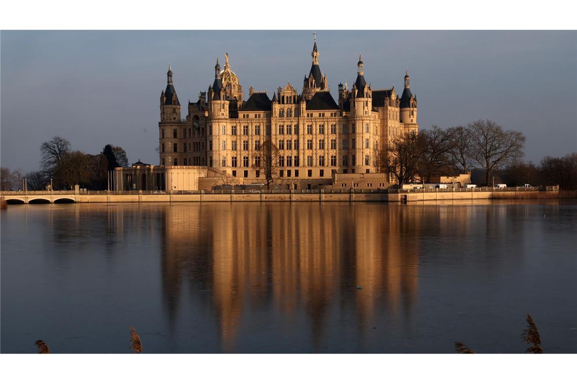 Bilder des Tages Das Schweriner Schloss spiegelt sich auf dem Eis auf dem Burgsee.