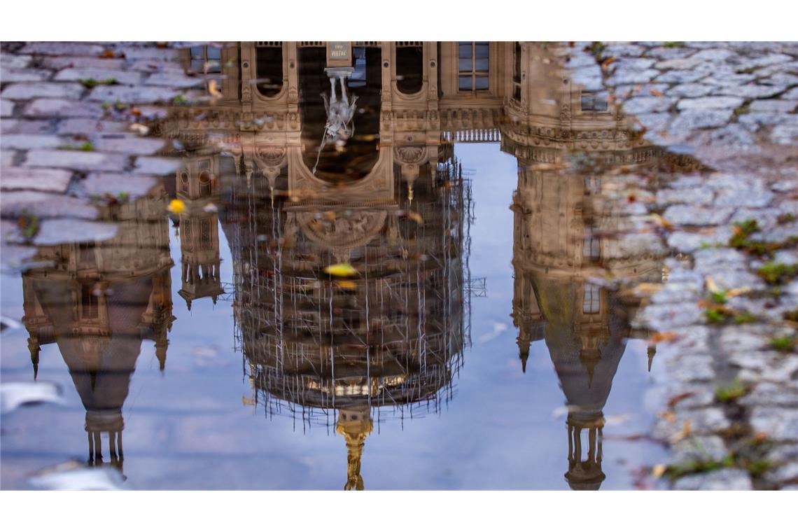 Bilder des Tages Das Schweriner Schloss spiegelt sich in einer Regenpfütze – graues, kühles und regnerisches Wetter zeigt den norddeutschen Sommer von seiner unfreundlichen Seite.