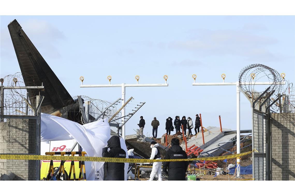 Mauer hinter Landebahn steht im Fokus der Ermittlungen Das Wrack einer Boeing 737-800 der südkoreanischen Fluggesellschaft Jeju Air liegt auf dem internationalen Flughafen Muan.