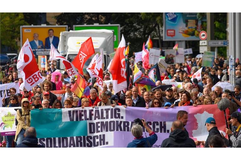 Demonstranten gehen durch die Innenstadt und tragen ein Banner mit dem Aufdruck "Vielfältig. Demokratisch. Solidarisch."
