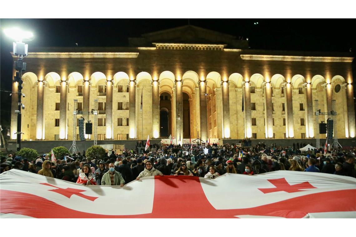 Bilder des Tages Demonstranten mit einer riesigen georgischen Nationalflagge versammeln sich vor dem georgischen Parlamentsgebäude, um die Freilassung politischer Gefangener und Neuwahlen zu fordern.