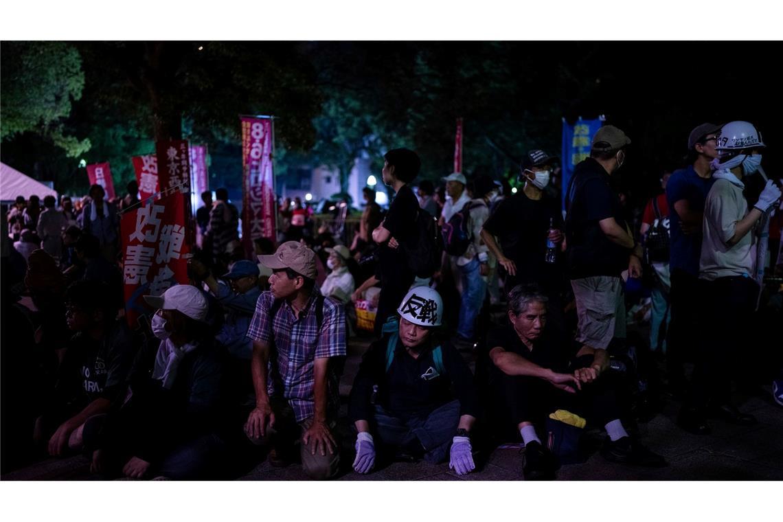 Demonstranten sitzen vor der Atombombenkuppel vor dem Gedenkgottesdienst zum 80. Jahrestag des US-Atombombenabwurfs auf Hiroshima im Zweiten Weltkrieg.