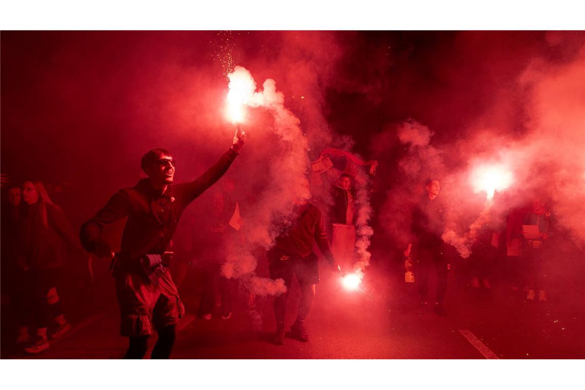 Demonstranten zünden Fackeln bei einer Kundgebung zum ersten Jahrestag der Bahnhofskatastrophe in Novi Sad an.