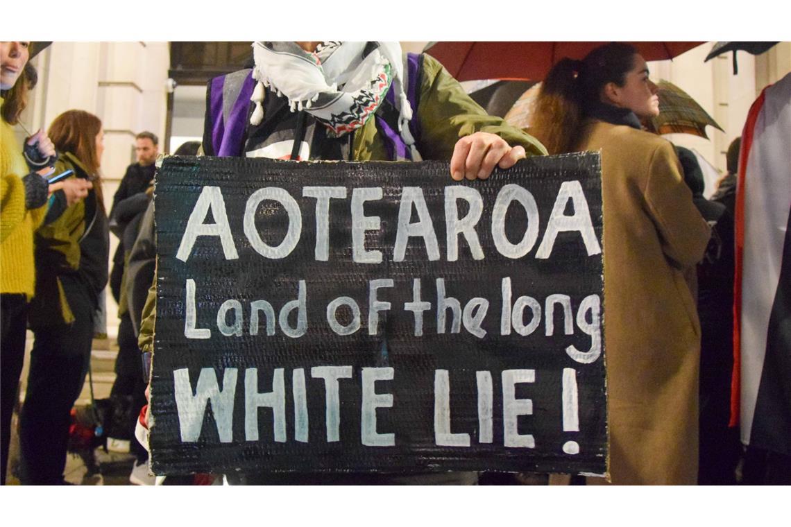 Über 40.000 Maori proben den Aufstand gegen ein neues Gesetz Demonstrierende protestieren mit Schildern gegen eine weiße Vorherrschaft.