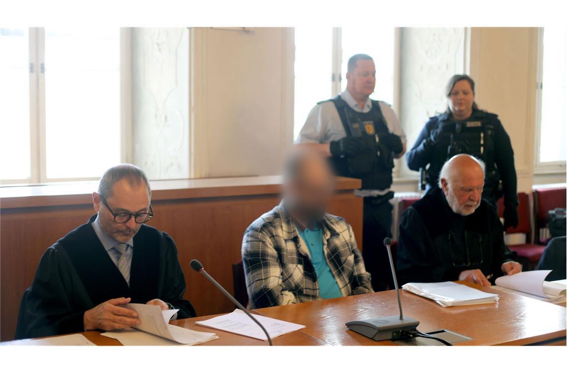 Der Angeklagte (M) und die Rechtsanwälte Andreas Kugel (l) und Raol Sander sitzen im Landgericht zu Beginn des Prozesses wegen versuchten Mordes.