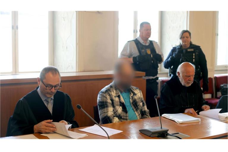 Der Angeklagte (M) und die Rechtsanwälte Andreas Kugel (l) und Raol Sander sitzen im Landgericht zu Beginn des Prozesses wegen versuchten Mordes.
