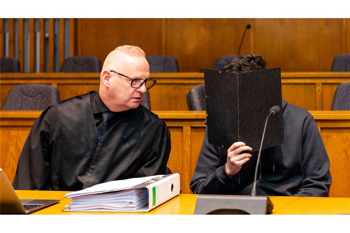 Der Angeklagte sitzt neben seinem Verteidiger im Gerichtssaal.