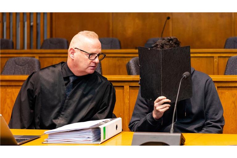 Der Angeklagte sitzt neben seinem Verteidiger im Gerichtssaal.