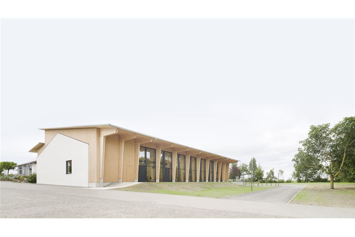 Junge Stuttgarter Architekten entwerfen ein Haus fürs ganze Dorf Der Bestand ist hell verputzt, der Aufbau in Holz – beide Zeitschichten sollten ablesbar bleiben. Die seitliche Fassade auf der Westseite . . .