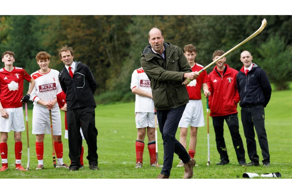 Der britische Prinz William (Mitte), Prince of Wales, betätigt sich sportlich auf dem Spielfeld während eines Besuchs beim Bute Shinty Club in Rothesay auf der schottischen Insel Bute.