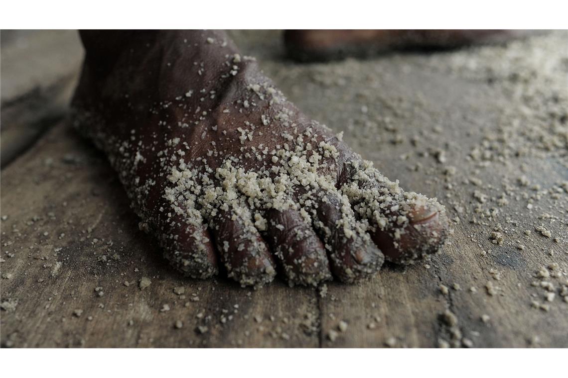 Der Fuß eines Arbeiters ist in einer Rohsalzraffinerie in Bangladesch mit Salz bedeckt.