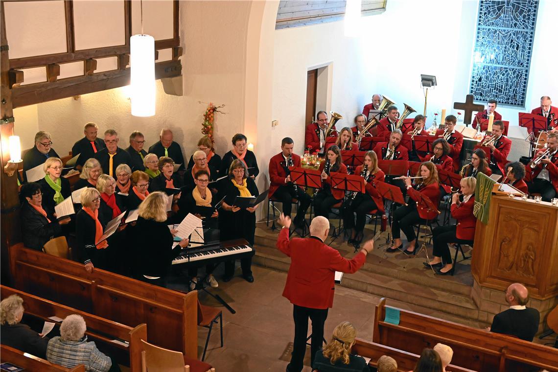 Blasmusik trifft Chorgesang bei Gemeinschaftskonzert Der gemischte Chor (links) und die Kapelle im Altarraum mit Dirigent Klaus Nübel.