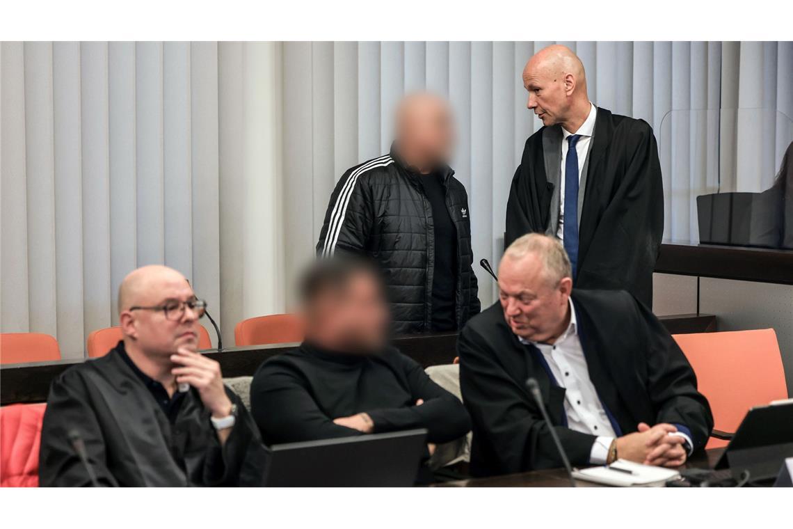 Panne im Prozess um Schumacher-Erpressung Der Hauptangeklagte (hinten, links) spricht im Gerichtssaal mit seinem Verteidiger Oliver Doelfs (hinten, rechts).