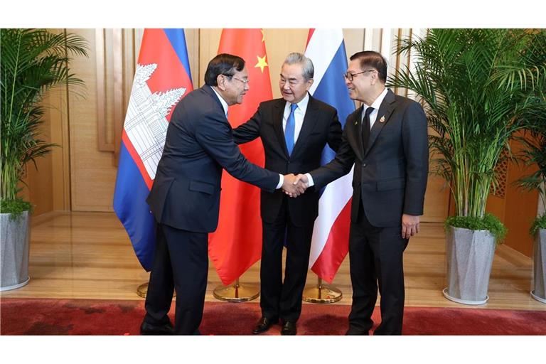Der kambodschanische Außenminister Prak Sokhonn (l) schüttelt die Hand seines thailändischen Amtskollegen Sihasak Phuangketkeow (r) vor dem chinesischen Amtskollegen Wang Yi.