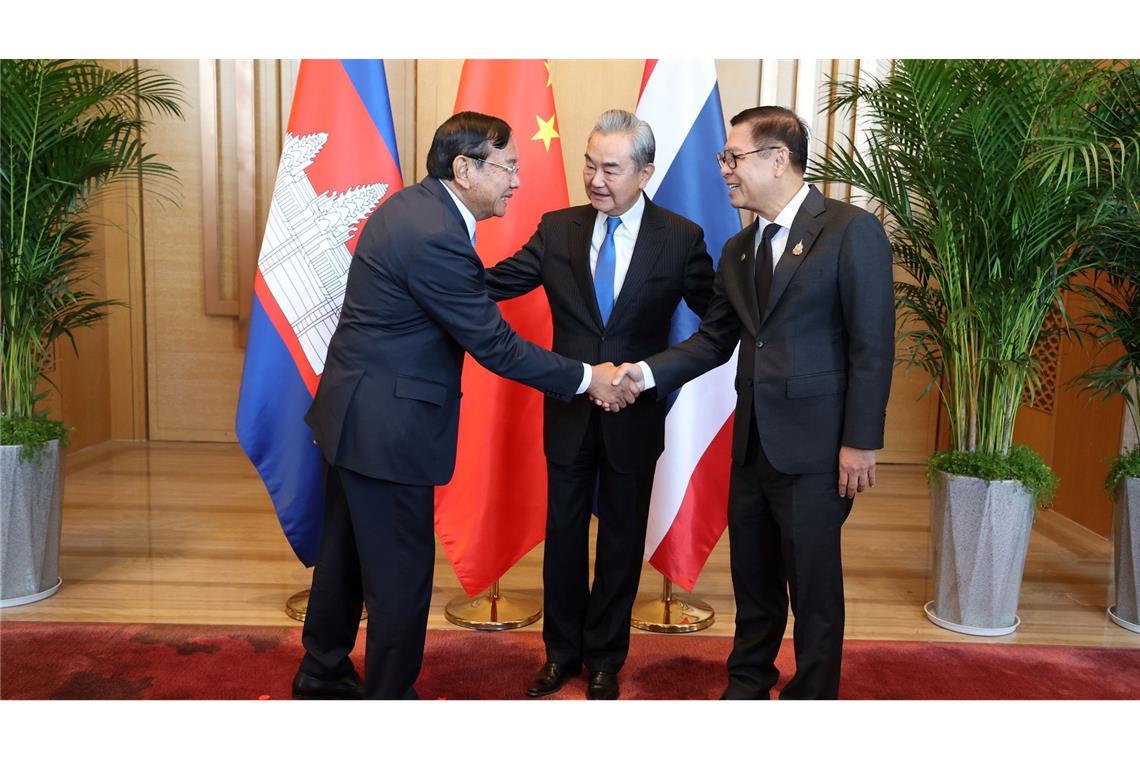 Der kambodschanische Außenminister Prak Sokhonn (l) schüttelt die Hand seines thailändischen Amtskollegen Sihasak Phuangketkeow (r) vor dem chinesischen Amtskollegen Wang Yi.