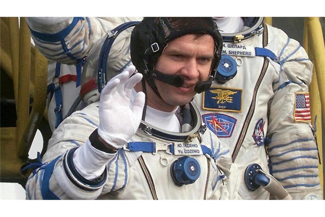 Der Kommandant der ersten Langzeitmission zur Internationalen Raumstation, der amerikanische Astronaut Bill Shepherd (M), und die russischen Kosmonauten Juri Gidsenko (unten) und Sergej Krikaljow (oben) winken, bevor sie auf dem Kosmodrom in das Raumschiff "Sojus-TM-31" einsteigen. (Archivbild)