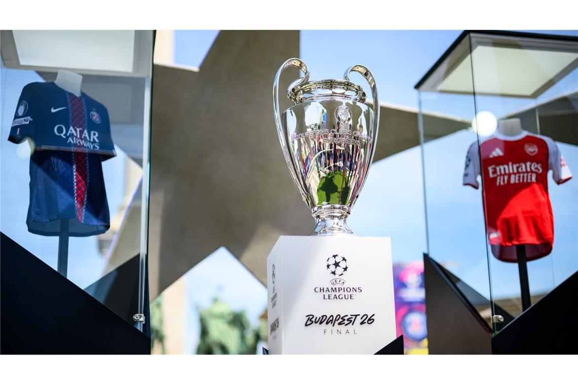 Der Pokal der Champions League steht zwischen den Trikots der Finalteams Paris Saint-Germain und FC Arsenal.