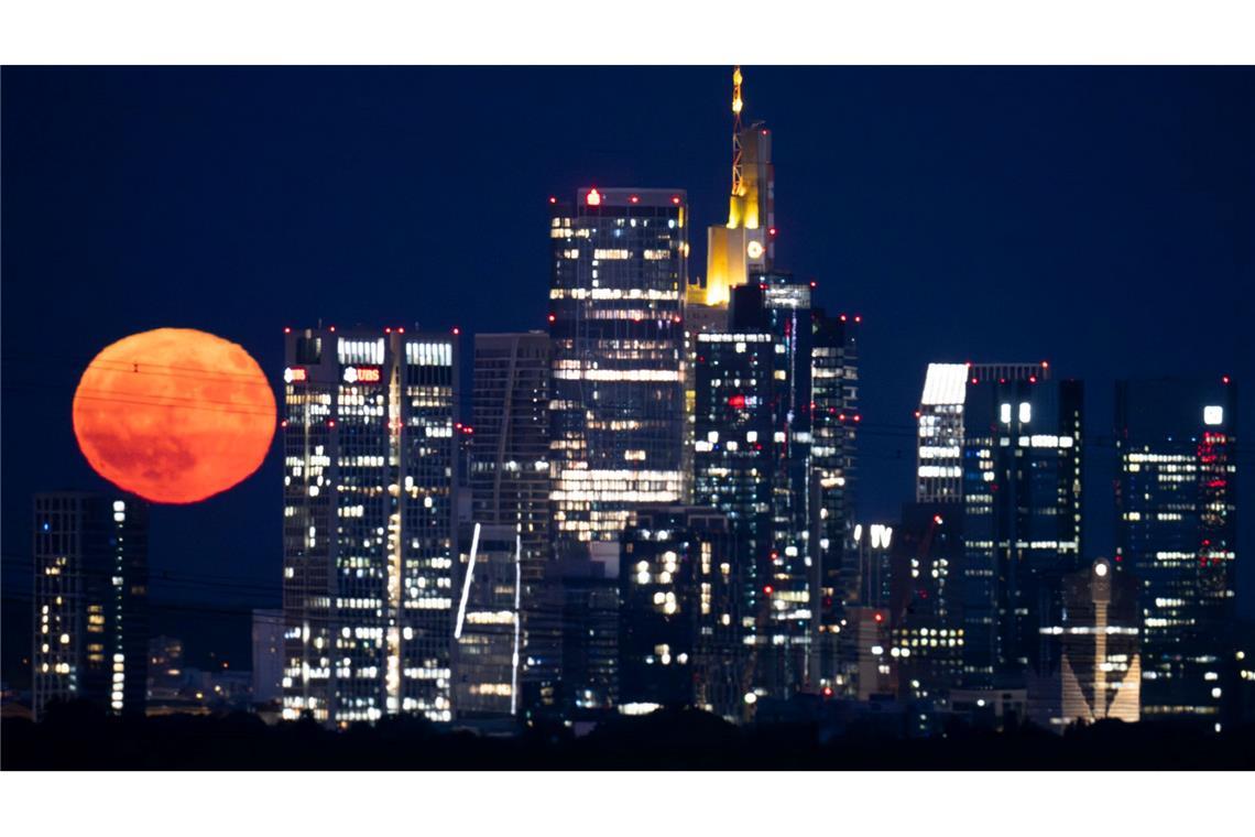 Bilder des Tages Der riesig wirkende "Erdbeermond" steht über der Bankenskyline von Frankfurt am nächtlichen Himmel.