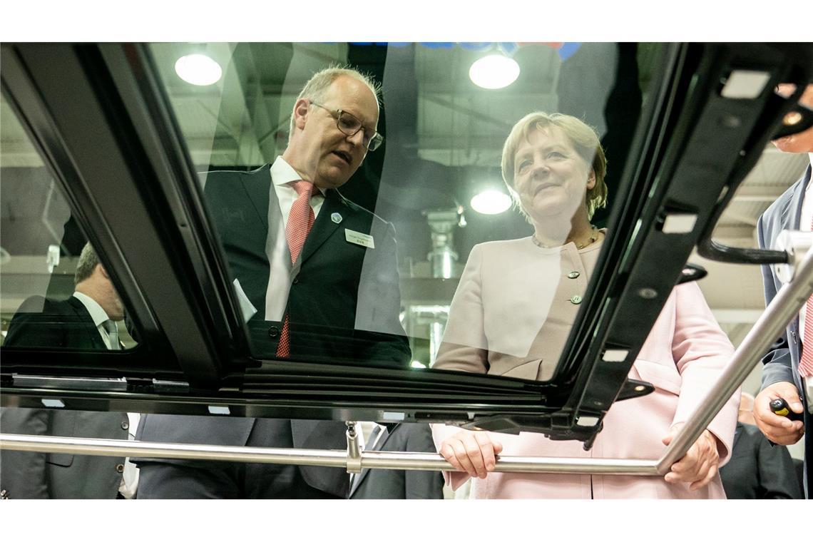 Webasto-Chef Engelmann räumt vorzeitig seinen Posten Der scheidende Webasto-Chef Holger Engelmann in besseren Tagen im Jahr 2019. Hier demonstriert der Manager der früheren Bundeskanzlerin Angela Merkel in einem Werk im chinesischen Wuhan die Fertigung von Schiebedächern.