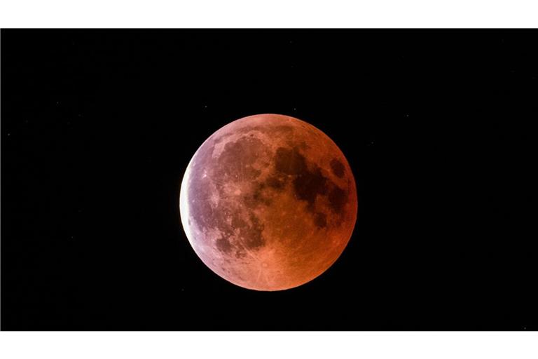 Der teilweise vom Erdschatten verdunkelte Vollmond leuchtet während einer Mondfinsternis rötlich. (Archivbild)