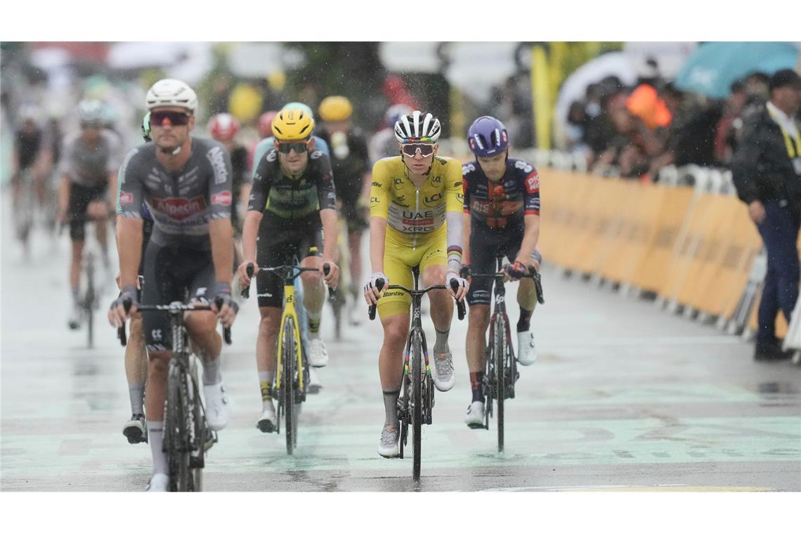 Der Tour-Führende Tadej Pogacar kommt bei Regen ins Ziel.