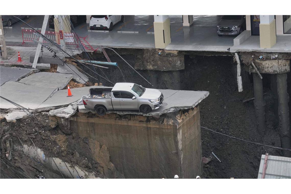 Bilder des Tages Der Weg ist weg. In Bangkok ist eine Straße eingestürzt und dieser Pickup steht deshalb plötzlich an einem Abgrund.