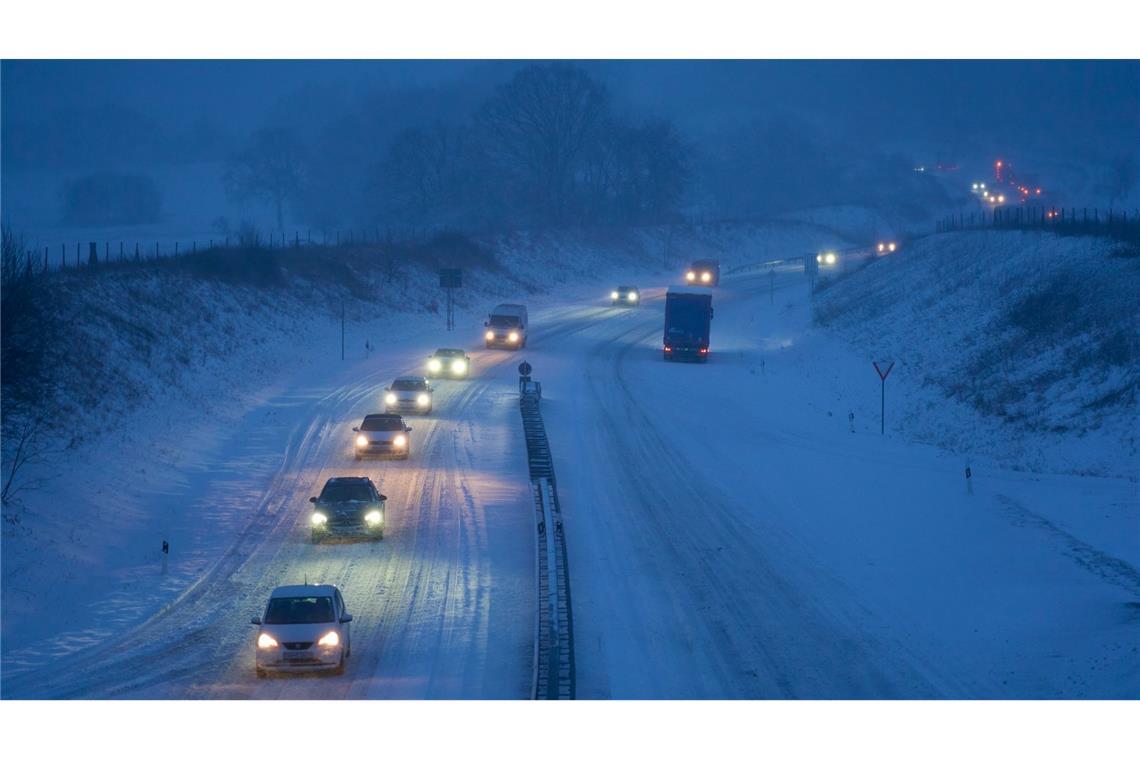 Der Winter ist zurück: Autos fahren auf einer verschneiten Straße in Fahrtrichtung Rennerod in Rheinland-Pfalz.